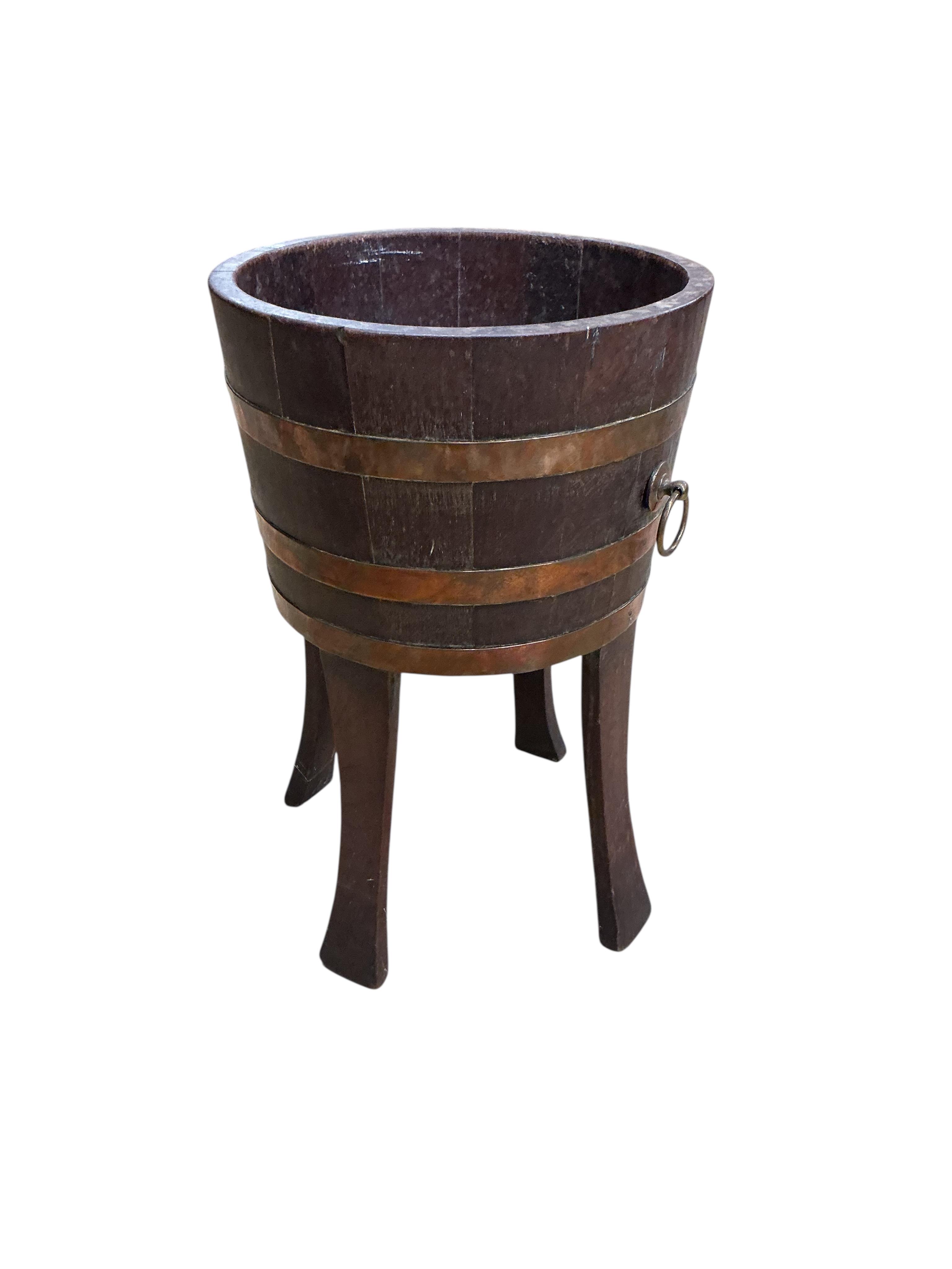 A copper bound staved oak circular jardiniere, late 19th century, maker's stamp Champion RD, diameter 33cm, height 53cm